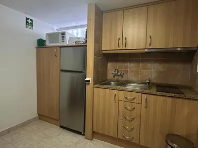 a kitchen with a stainless steel refrigerator and a microwave at Açoteias Secrets in Albufeira