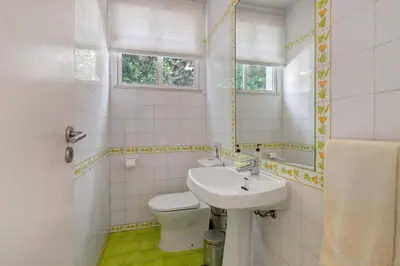 a white bathroom with a sink and a toilet at Casa do Pateo in Guia
