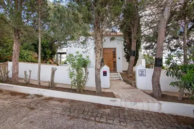 a white house with a fence and trees at Casa do Pateo in Guia