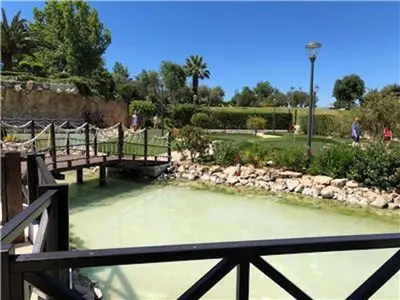 a view of a pond with benches in a park at Amazing ApartHotel Apartments 2 Bedroom in Albufeira in Albufeira