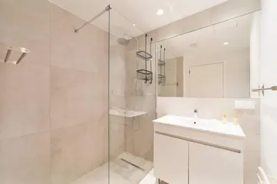 a white bathroom with a sink and a shower at Saro Apartment by HelloVacations in Albufeira