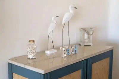 two white birds standing on a table with a vase at Apartamento de 2 quartos Hibiscus 40A na Praia de Sao Rafael - Albufeira, Algarve in Albufeira