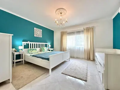 a bedroom with a bed and a blue wall at Casa Alfarroba - with heated indoor pool in Algoz