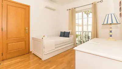 a white bedroom with a bed and a window at Vilamoura - VILLA LIMONI in Vilamoura
