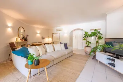 a living room with a white couch and a tv at Jardins do Golfe at Vale do Lobo in Vale do Lobo