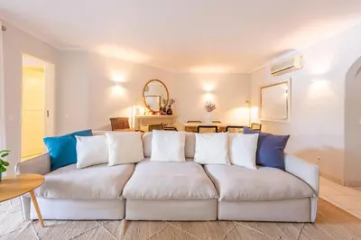 a white couch in a living room with a table at Jardins do Golfe at Vale do Lobo in Vale do Lobo