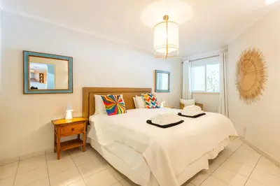 a bedroom with a large white bed and a window at Jardins do Golfe at Vale do Lobo in Vale do Lobo