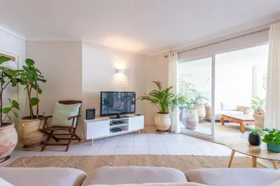 a living room with a tv and potted plants at Jardins do Golfe at Vale do Lobo in Vale do Lobo