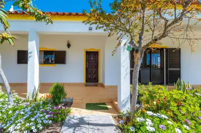 a white house with flowers in front of it at Villa 4 Quartos, Piscina, AC, Jardim, Prestige For Home in Loulé