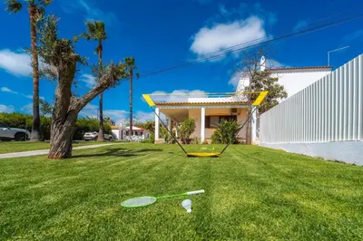 a yard with two tennis rackets in the grass at Villa 4 Quartos, Piscina, AC, Jardim, Prestige For Home in Loulé