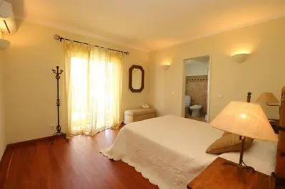 a bedroom with a white bed and a lamp at Villa Vilamoura, piscina privada in Quarteira