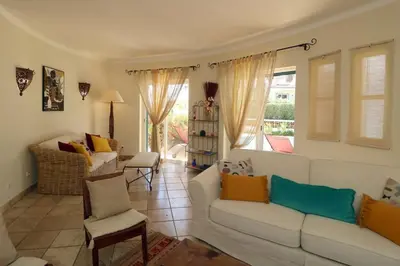 a living room with a white couch and chairs at Villa Vilamoura, piscina privada in Quarteira