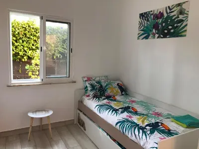 a small bedroom with a bed and a window at Toiago in Vilamoura
