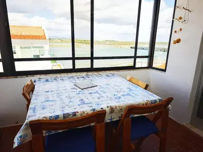 a table and chairs in a room with a large window at Blife Paulya private apartment in Faro