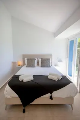a white bedroom with a large bed with pillows at Beautiful Villa with a Pool in Albufeira