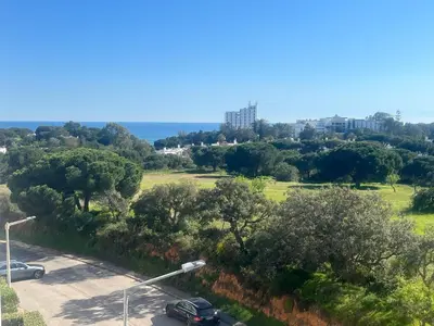 a kitchen with wooden cabinets and a black counter top at Penthouse, sea view, tennis, swimming pools, 3' foot golf in Olhos de Água
