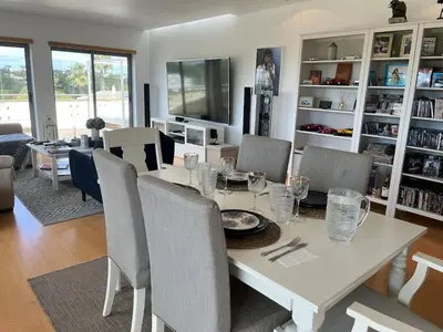 a dining room with a table with a tv on top at Penthouse, sea view, tennis, swimming pools, 3' foot golf in Olhos de Água