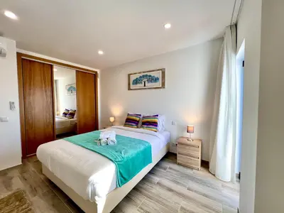 a bedroom with a bed with a green blanket at Vilamoura Design 2 by Homing in Vilamoura