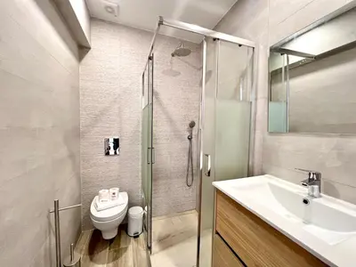 a bathroom with a shower and a toilet and a sink at Vilamoura Design 2 by Homing in Vilamoura