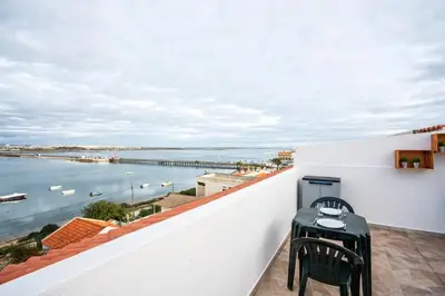 a balcony with a table and a view of the water at Blife Benya private apartment in Faro