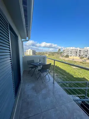 a patio with a table and chairs on a balcony at Fernandes Holidays in Quarteira
