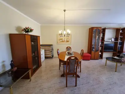 a living room with a table and a dining room at TAC - Bright Coast Quarteira in Quarteira