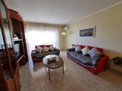 a living room with a couch and a table at TAC - Bright Coast Quarteira in Quarteira