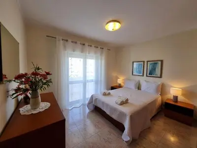 a bedroom with a white bed and a window at TAC - Bright Coast Quarteira in Quarteira