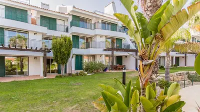 an apartment building with a lawn in front of it at SomeSunnyDay Vila Sol Village in Quarteira