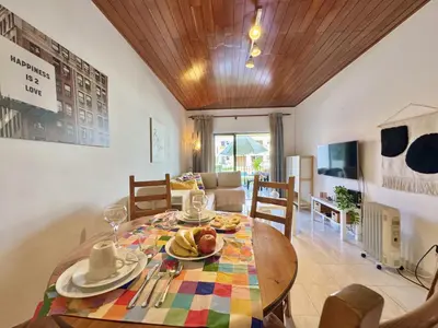a dining room with a wooden table with plates of food at Vilamoura Golf Apartment 2 With Pool by Homing in Vilamoura