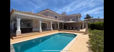a large house with a swimming pool in front of it at The Beverly Vilamoura in Quarteira