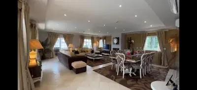 a living room with a couch and a table and chairs at The Beverly Vilamoura in Quarteira