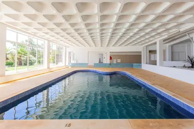 a swimming pool in a house with a ceiling at Beachfront apartment Praia dos Aveiros in Albufeira