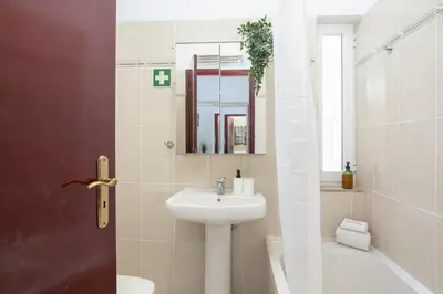 a bathroom with a sink and a toilet and a mirror at Aldeia do Mar Vilamoura, Pool Terrace, by Hopstays in Quarteira