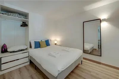 a bedroom with a large white bed and a mirror at Apartamento Condomínio Montechoro by CM Properties in Albufeira