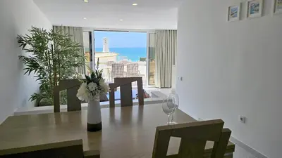 a dining room with a table and a view of the ocean at Albufeira, Blue Wave Retreat 64 in Albufeira