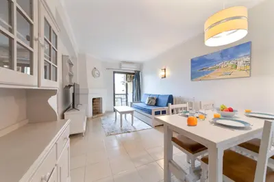 a kitchen and living room with a table and a dining room at Passport Beach - 201 by HelloVacations in Albufeira