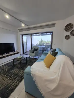 a living room with a blue couch and a television at Apartamento T2 86B na Praia Sao Rafael, Vista Mar - Albufeira in Albufeira