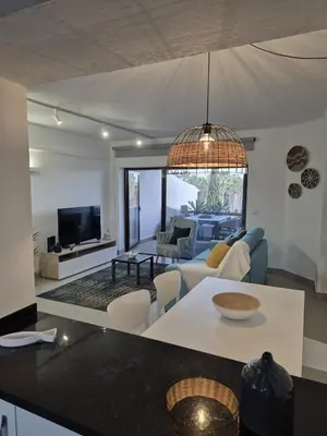 a living room with a couch and a tv at Apartamento T2 86B na Praia Sao Rafael, Vista Mar - Albufeira in Albufeira