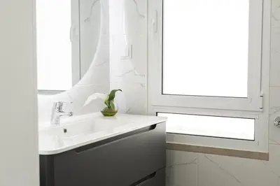 a white bathroom with a sink and a window at Flores 2Bedroom Apartment - Sea view Quarteira in Quarteira