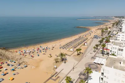 an aerial view of a beach with umbrellas and people at Flores 2Bedroom Apartment - Sea view Quarteira in Quarteira