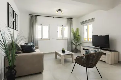 a living room with a couch and a tv at Flores 2Bedroom Apartment - Sea view Quarteira in Quarteira