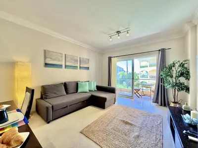 a living room with a couch and a table at Vilamoura Beach Village 1 With Pool by Homing in Vilamoura