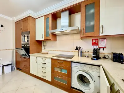 a kitchen with a washer and a washing machine at Vilamoura Beach Village 1 With Pool by Homing in Vilamoura