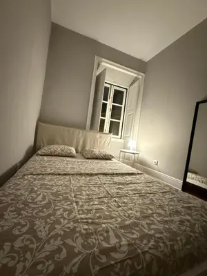 a bedroom with a large bed with a window at Faro Coast Guest House in Faro