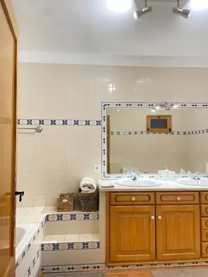 a bathroom with a sink and a mirror and a tub at Quinta da Calma with pool and BBQ in Boliqueime