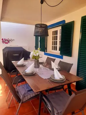 a dining room with a wooden table and chairs at Quinta da Calma with pool and BBQ in Boliqueime