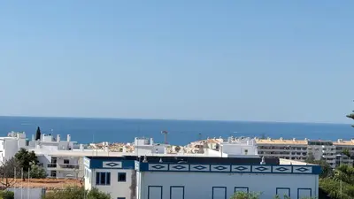 a city with white buildings and the ocean in the background at Cozy Sea View in Albufeira