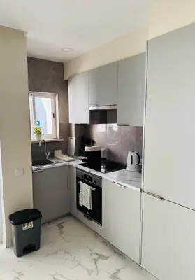a kitchen with white cabinets and a stove top oven at Excelente férias in Albufeira