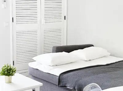 a bed with white sheets and pillows in a room at Sea View Apartment Albufeira in Albufeira